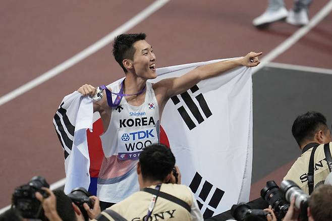 [도쿄=AP/뉴시스] 우상혁이 16일 일본 도쿄 국립경기장에서 열린 2025 도쿄 세계육상선수권대회 남자 높이뛰기 결선에서 2ｍ34로 은메달을 획득한 뒤 메달을 목에 걸고 기뻐하고 있다. 2025.09.16.