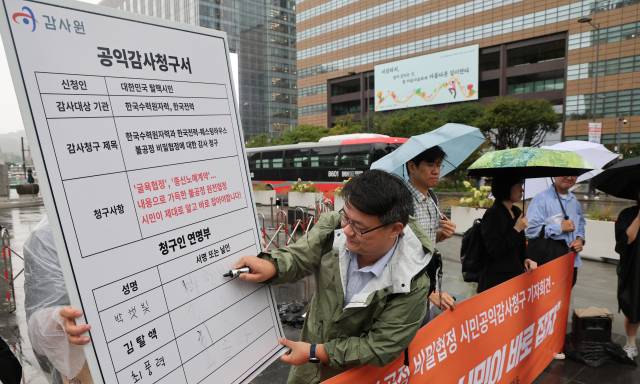 탈핵시민행동 관계자들이 17일 서울 종로구 광화문광장 이순신동상 앞에서 열린 한수원·한전·웨스팅하우스 불공정 비밀협정에 대한 시민공익감사 청구 기자회견에서 공익감사청구서 서명 퍼포먼스를 펼치고 있다. 뉴스1