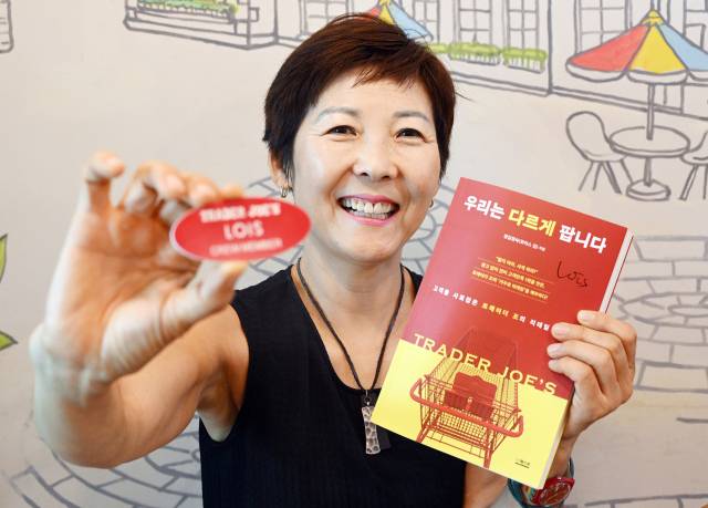 로이스 김 작가가 인터뷰를 마친 후 트레이드조에서 근무했을 때 패용했던 명찰과 최근 출간한 책 ‘우리는 다르게 팝니다’를 들어 보이고 있다. 오승현 기자