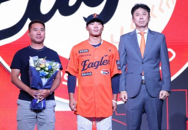 '2026 KBO 신인 드래프트'가 17일 서울 송파구 롯데호텔 월드 크리스탈볼룸에서 열렸다. 오재원(유신고)이 전체 3순위로 한화에 지명된 후 아버지, 손혁 단장과 기념촬영을 고 있다. /사진=김진경 대기자