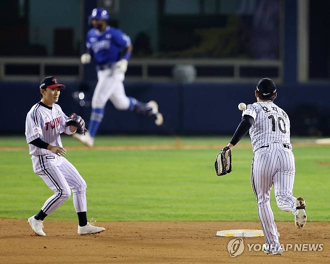 삼성 기회 끝내는 오지환-신민재 (서울=연합뉴스) 김도훈 기자 = 17일 서울 잠실야구장에서 열린 2024 신한 SOL뱅크 KBO 포스트시즌 플레이오프 3차전 LG 트윈스와 삼성 라이온즈의 경기. 8회초 2사 1, 2루 삼성 디아즈 땅볼 때 LG 오지환이 신민재에게 송구하며 아웃을 잡아내고 있다. 2024.10.17 superdoo82@yna.co.kr