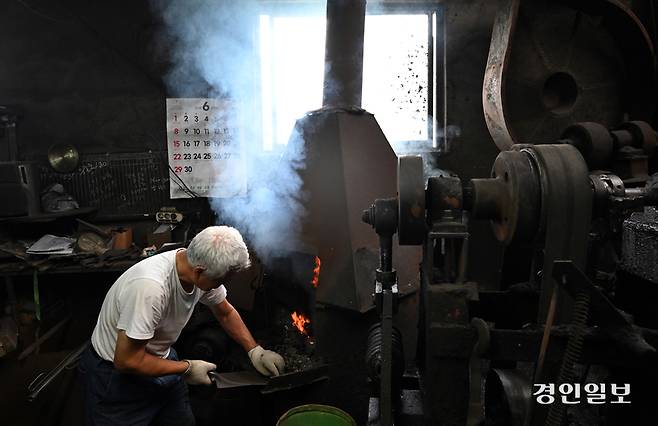 화덕에 장작을 넣고 있다.