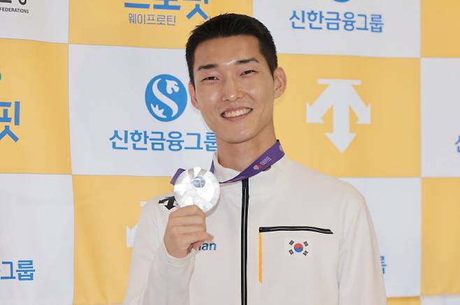 2025 도쿄 세계육상선수권대회 남자 높이뛰기 결선에서 은메달을 획득한 우상혁이 18일 서울 강서구 김포국제공항으로 귀국한 뒤 메달을 들어보이며 환하게 웃고 있다. 사진=연합뉴스