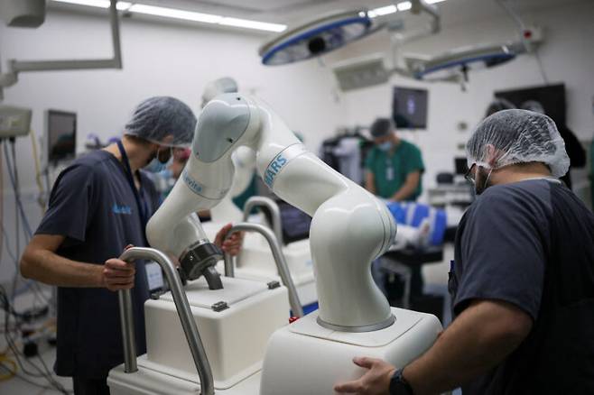실리콘밸리에 있는 인공지능‧로봇 의료기기 업체인 레비타 마그네틱스의 엔지니어들이  8일 칠레 산티아고의 클리니카 라스 콘데스에서 수술 준비를 위해 MARS(자기 보조 로봇 수술) 로봇 두 대를 옮기고 있다. 로이터=연합뉴스