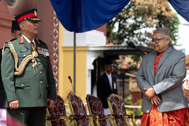 네팔의 수실라 카르키 신임 총리(오른쪽)와 아쇼크 라지 시그델 네팔 육군참모총장(왼쪽)이 2025년 9월 15일 네팔 카트만두에서 시위대에 의해 불타버린 대통령 집무실 앞에서 열린 신임 장관 취임식에 참석하고 있다. /연합뉴스
