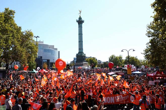 CFDT 노동조합기를 든 시위자들이 18일(현지시간) 파리 바스티유 광장에 모여 정부와 차기 예산 삭감에 반대하는 전국적인 총파업 과 시위의 일환으로 시위를 벌이고 있다. /로이터=뉴스1