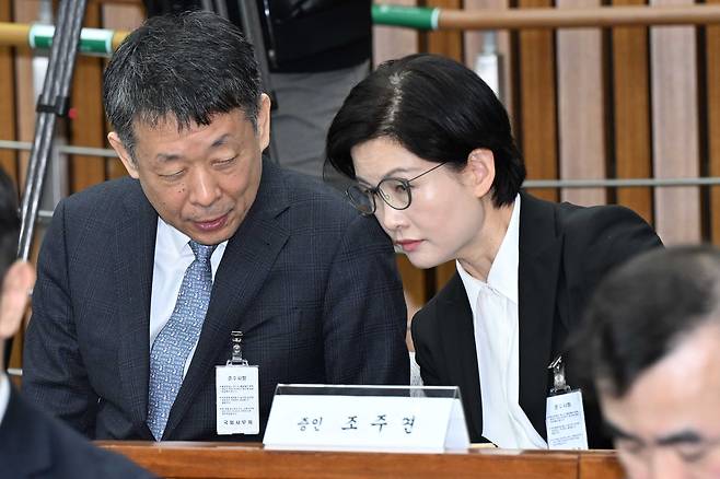 김광일 MBK 파트너스 부회장 겸 홈플러스 공동대표와 조주연 홈플러스 공동대표가 지난 3월 18일 서울 여의도 국회에서 열린 정무위원회 ‘홈플러스·MBK 파트너스 및 삼부토건’에 대한 긴급 현안질의에 증인으로 출석해 대화하고 있다. [국회사진기자단]