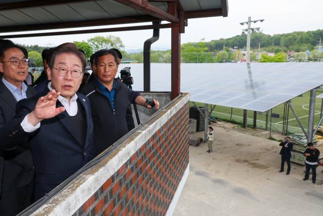 이재명 대통령이 대선 후보 시절인 5월 경기 여주시의 한 마을에 설치된 태양광 시설을 둘러보고 있다. 뉴스1