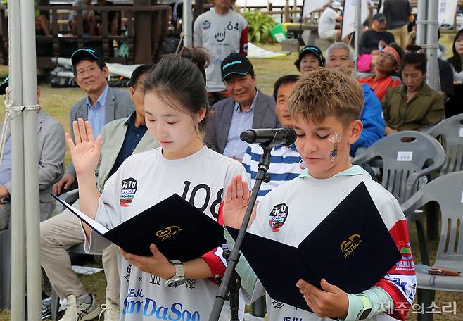 19일 열린 제3회 제주국제슈퍼컵카이트보딩대회 개막식에서 15개 참가국 선수단을 대표해 아르노(싱가포르, 사진 오른쪽) 선수와 이예진(대한민국) 선수가&nbsp; 대표 선서를 하고 있다. ⓒ제주의소리