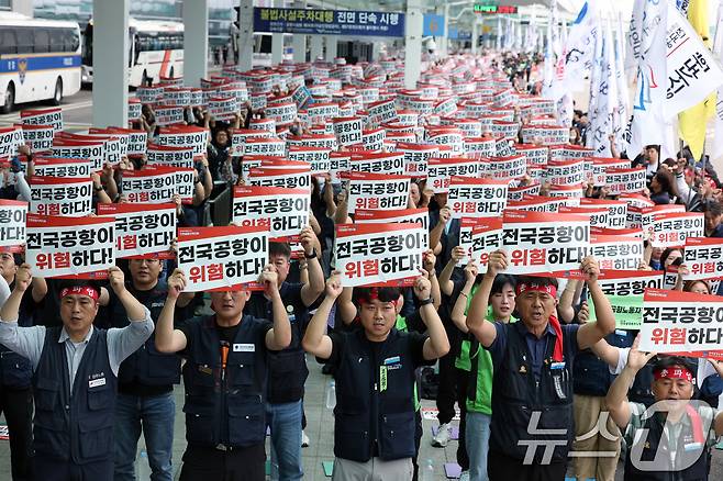 엄길용 민주노총 전국공공운수노조 위원장(오른쪽 두 번째)과 정안석 공공운수노조 인천공항지역지부장, 전국공항노동조합 등 전국공항노동자연대 조합원 등이 19일 오전 인천국제공항 2터미널에서 열린 안전한 일터·안전한 공항을 위한 전국공항노동자 총파업 대회에서 구호를 외치고 있다.2025.9.19/뉴스1 ⓒ News1 박정호 기자