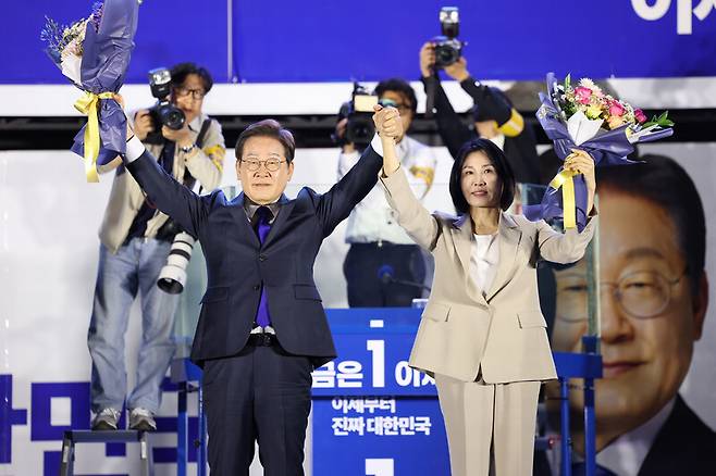이재명 대통령과 김혜경 여사가 서울 여의도 국회 앞에서 당선 축하 꽃다발을 받은 뒤 시민들을 향해 인사하고 있다. 공동취재사진