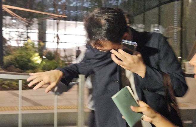 김건희 여사 오빠인 김진우 씨가 지난 7월 28일 김 여사 관련 의혹들을 수사하는 민중기 특별검사팀 사무실이 위치한 서울 종로구 KT광화문빌딩에서 조사를 마친 뒤 얼굴을 가린 채 특검 사무실을 나서고 있다. [사진=연합뉴스]