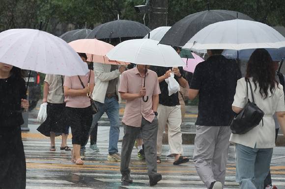 서울 종로구 광화문광장 인근에서 우산을 쓴 시민들이 발걸음을 재촉하고 있다. [사진=연합뉴스]