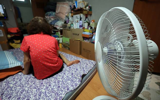 무더운 날씨가 이어진 지난 7월 서울의 한 쪽방촌에서 주민이 선풍기로 더위를 식히고 있다. 뉴스1