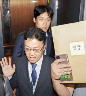 압수수색 영장을 든 김건희 특검팀이 지난 18일 서울 여의도 국민의힘 중앙당사에 진입하기 위해 승강기에 오르고 있다.  /연합뉴스