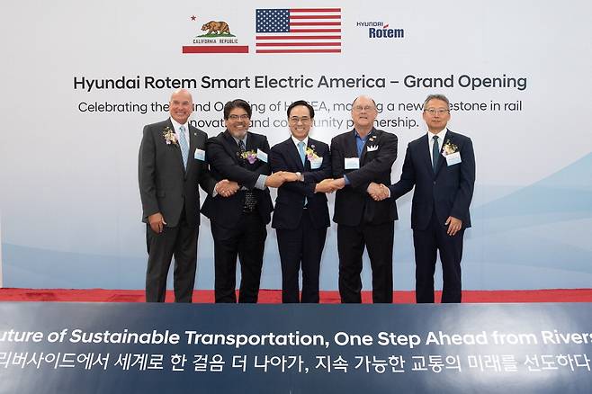 이용배 현대로템 대표이사 사장(왼쪽 셋째)이 18일(현지시간) 미국 캘리포니아주 리버사이드시에서 '현대로템 스마트 일렉트릭 아메리카(HRSEA)' 준공식을 열고 기념촬영을 하고 있다. 왼쪽부터 마이크 퓨트렐 리버사이드시 행정시장, 제스 몬테스 LA메트로 철도차량 사업총괄, 이 사장, 척 콘더 리버사이드시 시의원, 김영완 주LA 총영사. 현대로템