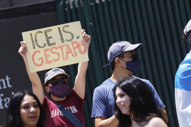 지난 6월 한 시위자가 미 로스앤젤레스의 메트로폴리탄 구치소 앞 시위에서 ‘이민세관단속국(ICE)은 게슈타포(독일 나치 비밀 경찰) ’라고 적힌 팻말을 들고 있다. AP 뉴시스