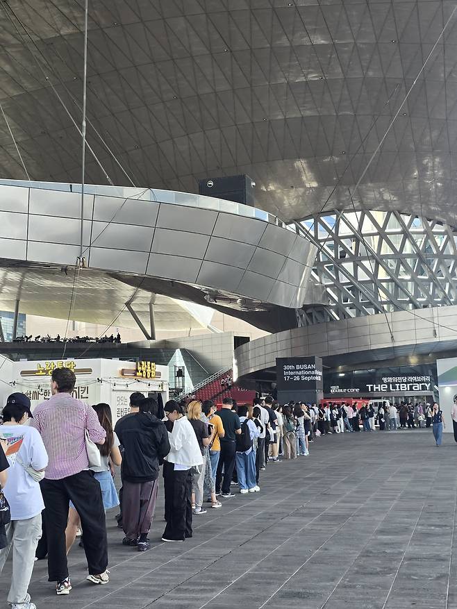 부산국제영화제가 열리는 영화의전당 두레라움 광장에 굿즈를 사기 위한 대기 줄이 길게 늘어서 있다. 손미정 기자