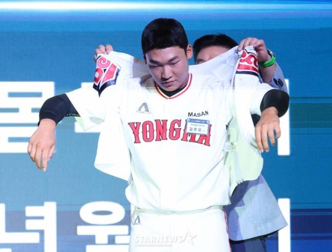'2026 KBO 신인 드래프트'가 17일 서울 송파구 롯데호텔 월드 크리스탈볼룸에서 열렸다.  김주오(마산용마고)가 전체 7순위로 두산에 지명된 후 김태룡 단장의 도움을 받아 유니폼을 입고 있다. /사진=김진경 대기자