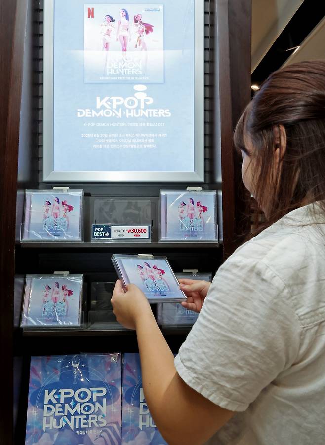 16일 서울 종로구 교보문고 광화문점을 찾은 시민이 케이팝 데몬 헌터스 음반을 살펴보고 있다.   미국 빌보드 예고 기사에 따르면 ‘케이팝 데몬 헌터스’ 속 가상 K팝 걸그룹 헌트릭스가 부른 곡 ‘골든’은 최신(9월 20일 자) 빌보드 메인 싱글 차트 ‘핫 100’ 1위를 기록하는 한편 가상 K팝 보이그룹 사자보이즈가 부른 ‘유어 아이돌’과 ‘소다 팝’은 각각 4위와 5위에 올랐다.   K팝 앨범이 빌보드 메인 차트를 동시에 차지한 건, 2020년 12월 그룹 방탄소년단(BTS)이 앨범 ‘비’(BE)와 타이틀곡 ‘라이프 고스 온’(Life Goes On)이 1위를 차지한 이후 처음이다. 2025.9.16/뉴스1