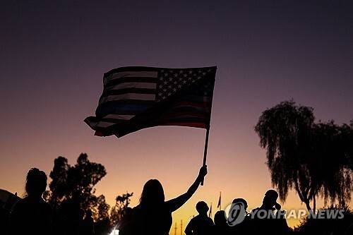사진은 찰리 커크 추모 집회에서 성조기 흔드는 미국인. [사진=AFP 연합뉴스 자료사진]