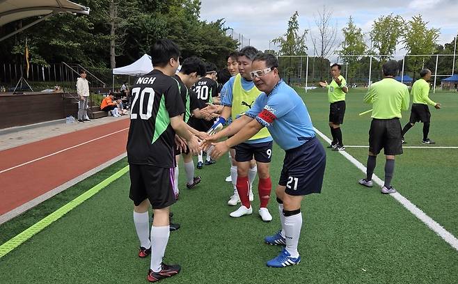 노석철 쿠키뉴스 대표(오른쪽)가 주장 완장을 차고 경기 시작 전 에너지경제 선수들과 인사하고 있다. /강아영 기자