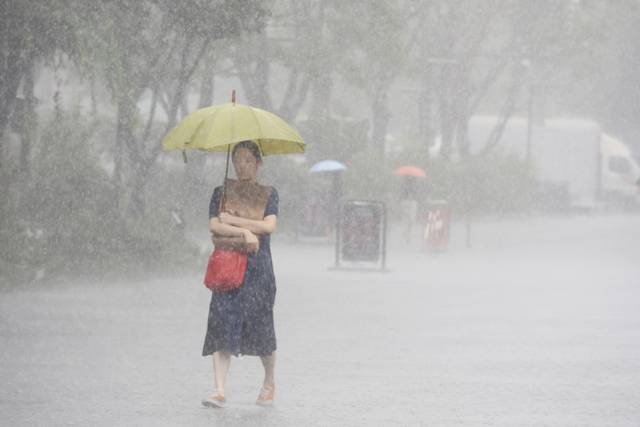▲ 기습 폭우가 쏟아진 지난 17일 서울 종로구 광화문광장 인근에서 우산을 쓴 시민이 쇼핑백을 젖지 않게 하기 위해 꼭 끌어안은 채 발걸음을 재촉하고 있다. 연합뉴스