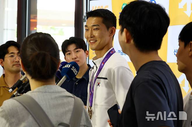 [서울=뉴시스] 박주성 기자 = 2025 도쿄 세계육상선수권대회 남자 높이뛰기에서 은메달을 획득한 우상혁 선수가 지난 18일 서울 강서구 김포국제공항 입국장으로 귀국해 취재진의 질문에 답하고 있다. 2025.09.18. park7691@newsis.com