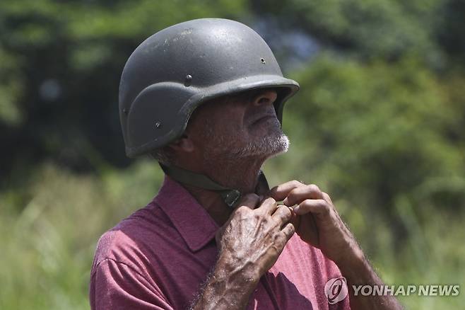 지난 13일(현지시간) 헬멧 착용하는 베네수엘라 민병대원 [AP 연합뉴스 자료사진. 재판매 및 DB 금지]