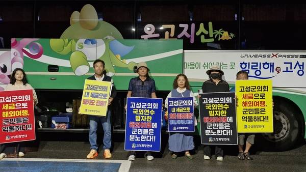 고성희망연대 회원들이 20일 오전 김해공항에서 군의회 외유성 국외출장 중단을 요구하며 피켓시위를 벌이고 있다. /고성희망연대