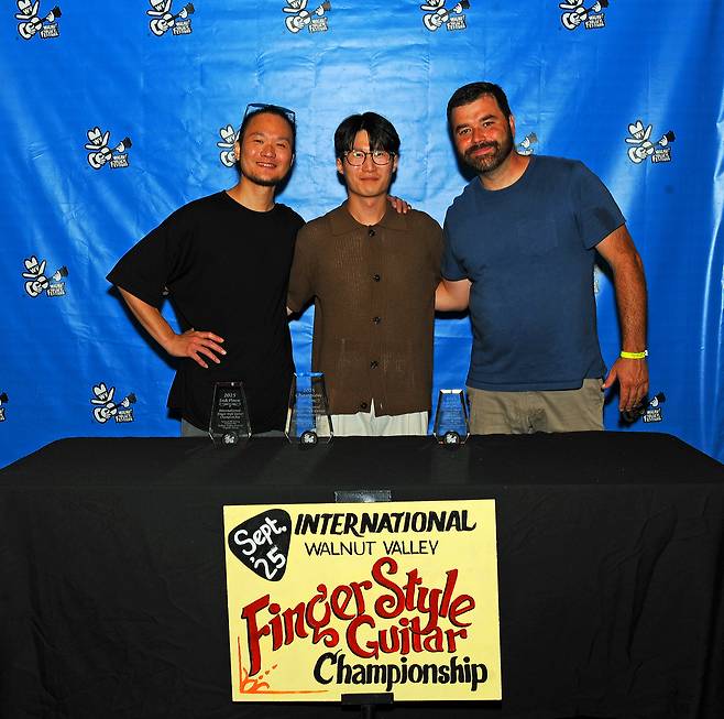 ‘제53회 월넛 밸리 페스티벌 2025 국제 핑거스타일 기타 챔피언십 대회’에서 1위를 차지한 포항 출신 기타리스트 김화종씨(30·미국 버클리 음대 4학년·가운데)가 장춘린(2위·타이베이), 브랜든 그린(3위·미국 웨스트 버지니아)과 기념사진을 촬영했다. /독자 제공