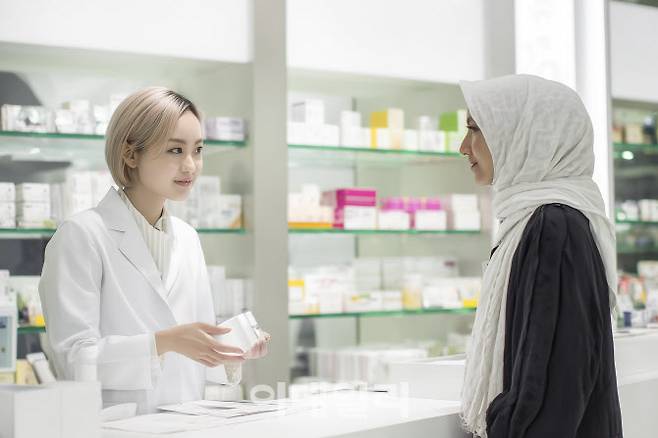 약사에게 약국 뷰티 제품에 대한 설명을 듣는 외국인 관광객의 모습. (출처=클립아트코리아)