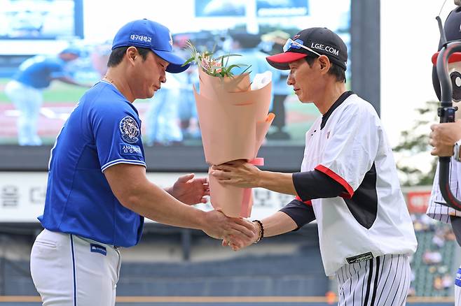 삼성 오승환(왼쪽)이 20일 잠실구장에서 열린 2025 KBO리그 LG전에 앞서 열린 자신의 은퇴투어 행사에서 LG 염경엽 감독 꽃다발을 받고 있다. 사진 | 삼성 라이온즈
