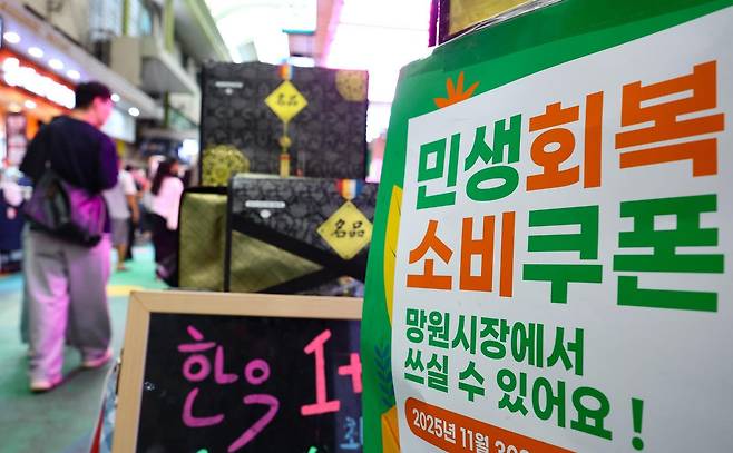 민생회복 소비쿠폰 2차 지급 신청일을 하루 앞둔 21일 서울 마포구 망원시장의 한 상점에 민생회복 소비쿠폰 사용가능 안내문이 게시돼 있다.  2차 소비쿠폰은 소득 하위 90% 국민에게 1인당 10만 원씩 지급되며, 온·오프라인 모두 신청 첫 주(9월 22~26일)에는 시스템 과부하와 주민센터 혼잡 방지를 위해 출생 연도 끝자리를 기준으로 요일제가 적용된다. 뉴시스