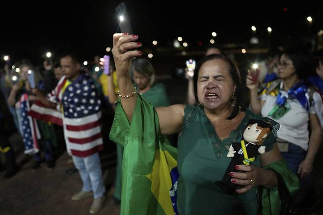 2025년 9월11일 브라질 수도 브라질리아에서 자이르 보우소나루 전 대통령 지지자들이 브라질 국기와 성조기를 두른 채 야간집회를 하고 있다. AP 연합뉴스