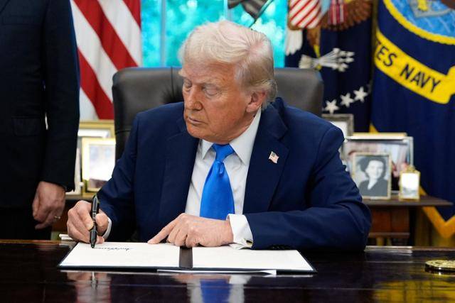 도널드 트럼프 미국 대통령이 19일 백악관 집무실에서 비자 관련 행정명령에 서명하고 있다. 워싱턴=AP 연합뉴스