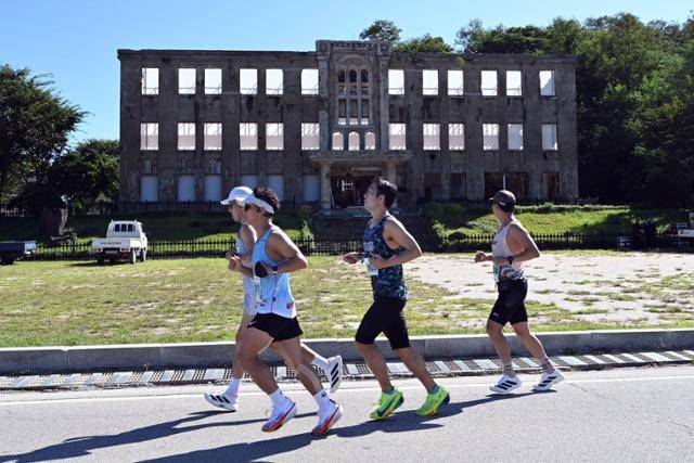 21일 열린 '제22회 철원DMZ국제평화마라톤대회' 풀코스 참가자들이 북한 노동당사 앞을 통과하고 있다. 철원=강예진 기자