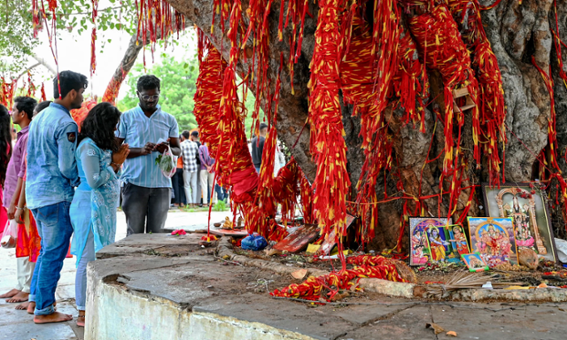 인도 텔랑가나주 하이데라바드 칠쿠르 발라지 사원에서 인도 청년들이 나무에 신성한 실을 묶은 후 기도를 올리고 있다. 영국 가디언 캡처