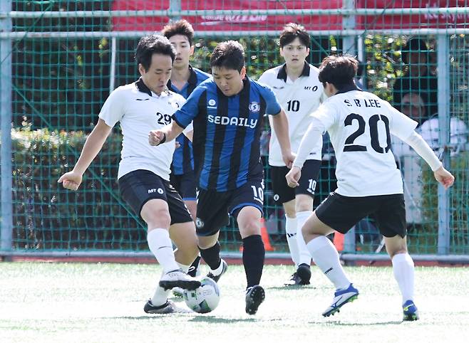 21일 서울 노원구 불암산스포츠타운에서 치러진 서울경제신문과 머니투데이의 16강전. 정문영 서울경제신문 기자가 상대 선수 사이에서 공을 빼돌리고 있다. /서울경제신문 제공