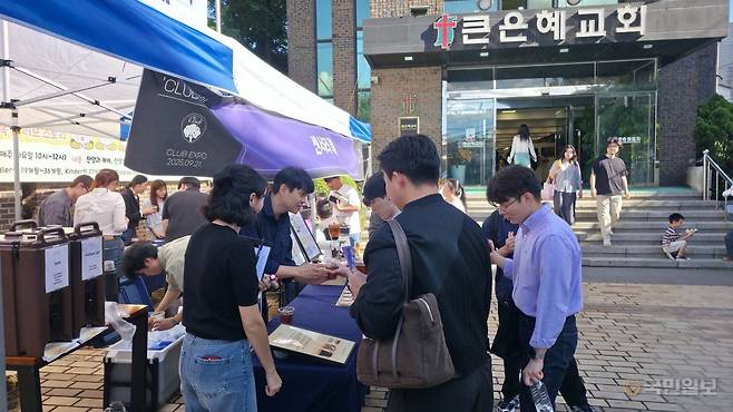 큰은혜교회 청년들이 21일 서울 관악구의 교회 앞 마당에서 열린 'CLUB 박람회'에서 커피 동호회 부스를 찾아 설명을 듣고 있다.
