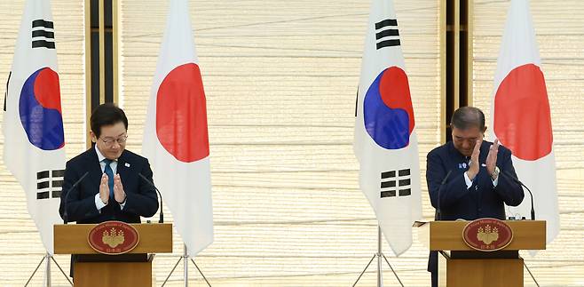 이재명 대통령과 이시바 시게루 일본 총리가 지난 23일 일본 도쿄 총리 관저에서 한일 정상 공동 언론 발표를 마친 뒤 박수치고 있다. [연합]