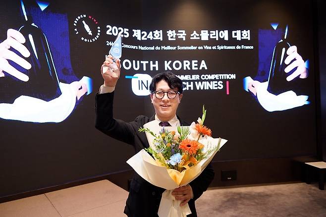 이형택 소믈리에가&nbsp;2025 한국 소믈리에 대회에서 우승한 뒤 트로피를 들고 활짝 미소&nbsp;짓고 있다. 홉스코치 코리아 제공