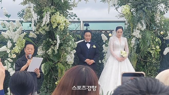 김병만(왼쪽에서 두 번째), 현은재 부부가 지난 20일 정오 서울 서초구 반포동 세빛플로팅아일랜드 루프탑에서 결혼식을 올리고 선배 김학래(왼쪽)의 성혼선언문을 듣고 있다. 사진 스포츠경향DB