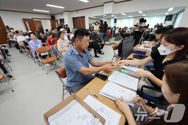 2차 민생회복 소비쿠폰 신청 첫 날인 22일 광주 북구 두암3동 행정복지센터에 시민들이 신청 후 선불카드를 수령하고 있다. 2025.9.22/뉴스1 ⓒ News1 박지현 기자