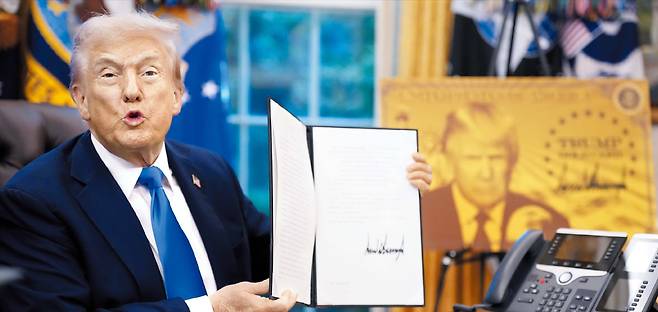 도널드 트럼프 미국 대통령이 19일 전문직 취업 비자로 알려진 ‘H-1B 비자’ 신청 수수료를 기존 1000달러에서 10만달러로 인상하는 내용의 포고문에 서명했다. 이 비자는 미국이 전 세계 우수 인재들을 흡수해 첨단 기술 초격차를 유지할 수 있게 한 근간이었다. 하지만 “미국인 일자리를 위협한다”며 스스로 문턱을 대폭 높인 것이다. 사진은 트럼프가 같은 날 100만달러를 내면 신속한 영주권 심사를 받을 수 있는 ‘골드카드’ 비자 도입 행정명령서에 서명한 뒤 이를 들어 보이는 모습. /게티이미지코리아