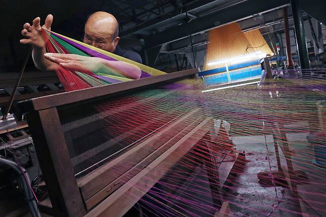 지난 15일 충남 공주시 유구읍 동원직물 공장에서 조건환씨가 여러 색의 실을 정경기에 연결하고 있다. 백소아 기자 thanks@hani.co.kr