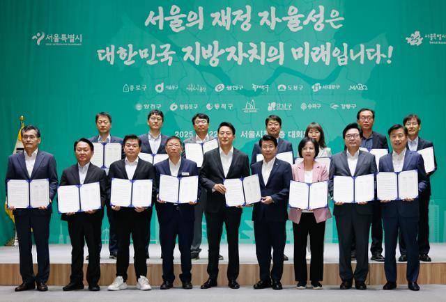오세훈(앞줄 왼쪽 다섯 번째) 서울시장이 22일 중구 서울시청에서 열린 서울시-구청장협의회 지방재정 공동선언에서 15개 자치구 구청장, 부구청장과 함께 공동선언문을 들고 기념 촬영을 하고 있다. 송파구 제공