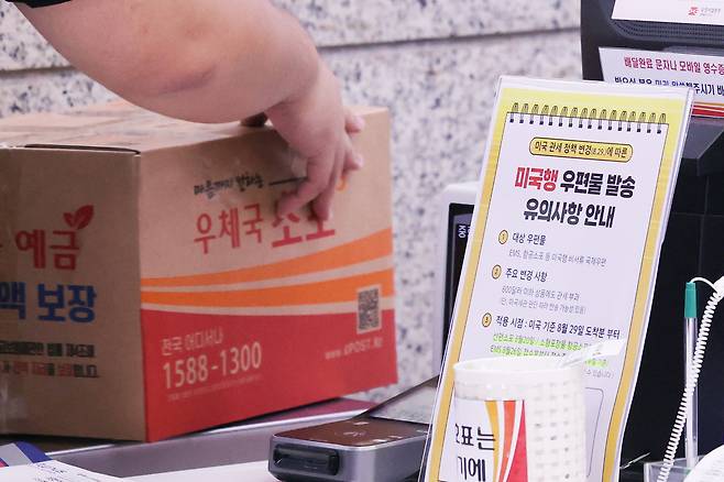 Customer weighs a parcel at the Post Office in Jongno District, central Seoul, on Aug. 25 [YONHAP]