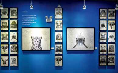 작가가 2021년부터 해온 공공 예술 캠페인 ‘#KOHEXIST’의 모습. 동물 드로잉 위에 공존과 화합의 메시지를 담은 작품이 전시실 한쪽 벽면을 채우고 있다.