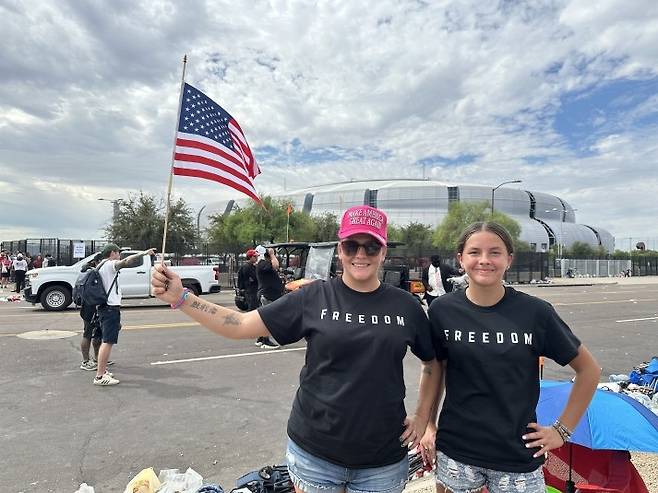 찰리 커크 추모식에 참석하려 온 캐츠 가족 (글렌데일[미 애리조나주]=연합뉴스) 임미나 특파원 = 21일(현지시간) 오전 10시께 미국 애리조나주 피닉스 외곽 글렌데일의 스테이트팜 스타디움 앞에서 찰리 커크 추모식에 참석하려고 온 레일라 캐츠(31) 씨와 딸이 성조기를 흔들고 있다. mina@yna.co.kr